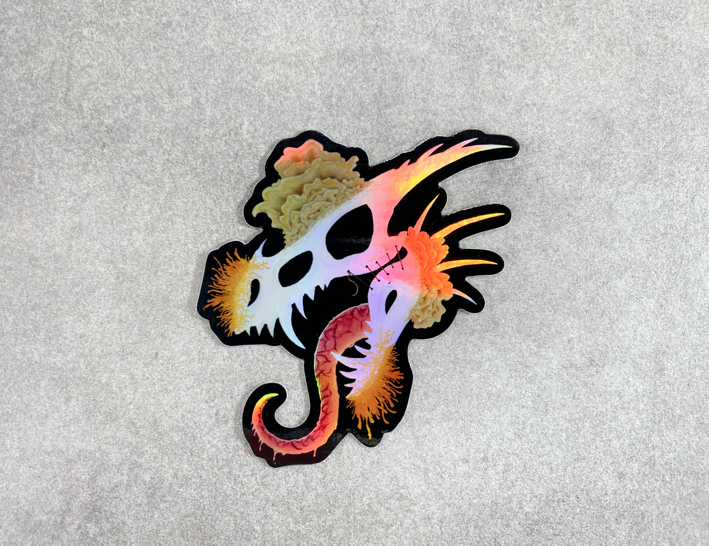 dragon skull with three different types of mushrooms growing from it on a holographic sticker