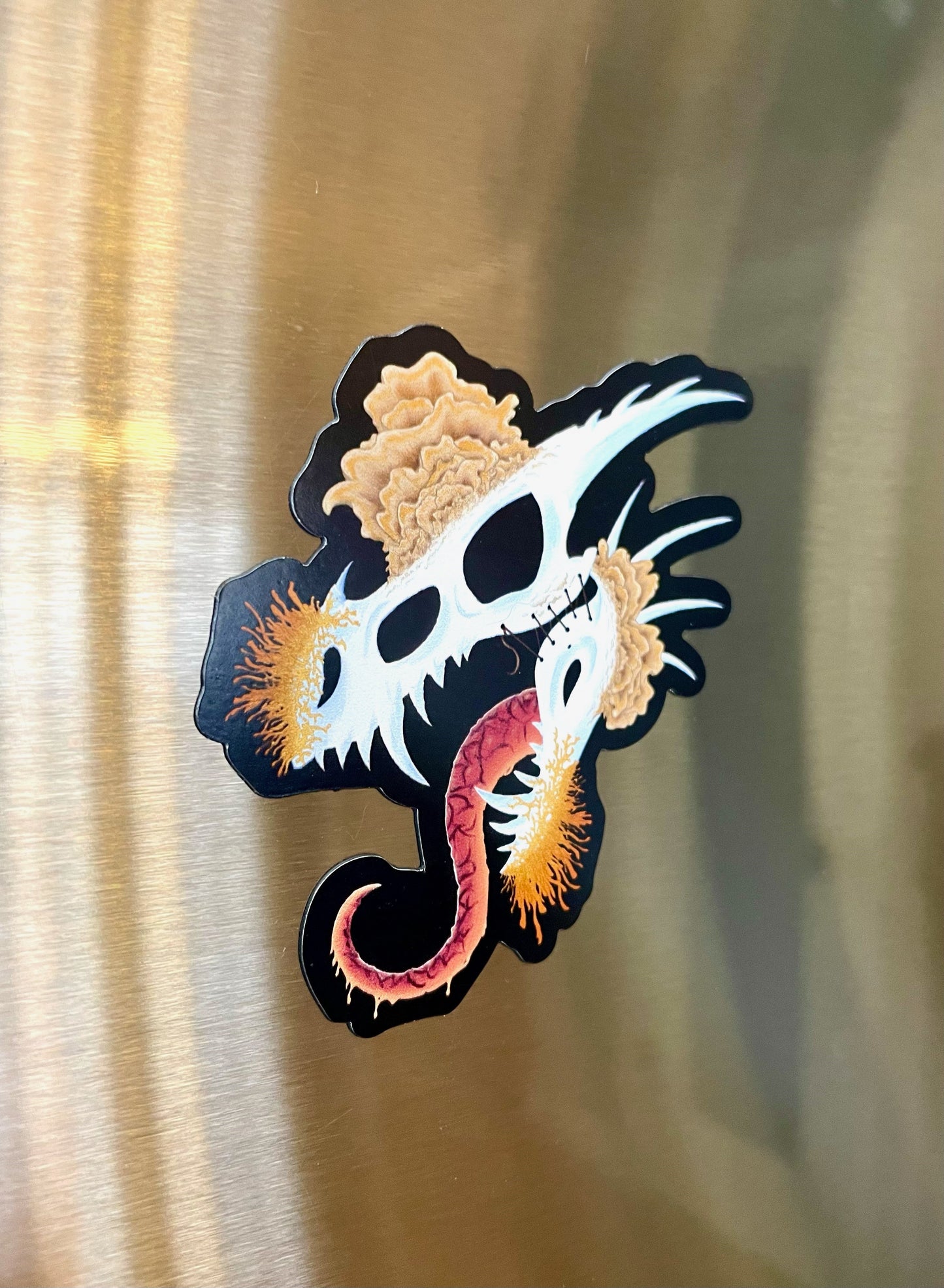 dragon skull with three different types of mushrooms growing from it on a magnet art
